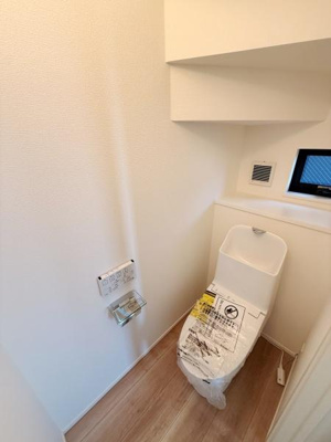 清潔感のあるトイレ空間です。窓があり換気がしやすい設計となっています。床材の色合いが柔らかく全体的に明るい印象です。シンプルですっきりとした内装です。