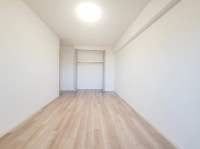 明るい光が差し込む洋室です。ナチュラルなフローリングが空間をすっきりと見せています。シンプルな内装でお好みのインテリアが楽しめます。収納スペースも備えられています。