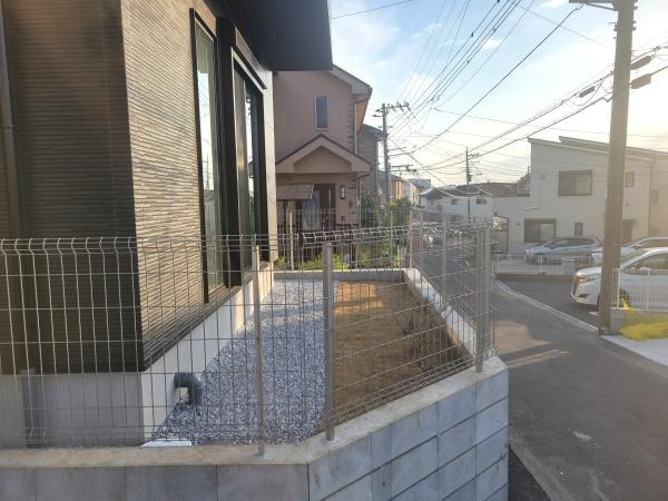 フェンスで囲まれた敷地が道路沿いに広がり住まいの外観がすっきりとしています。道路側からの視認性も高く車の出し入れや動線がスムーズに確保されます。お手入れの行き届いた外構が建物を引き立てています。
