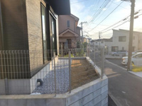 フェンスで囲まれた敷地が道路沿いに広がり住まいの外観がすっきりとしています。道路側からの視認性も高く車の出し入れや動線がスムーズに確保されます。お手入れの行き届いた外構が建物を引き立てています。