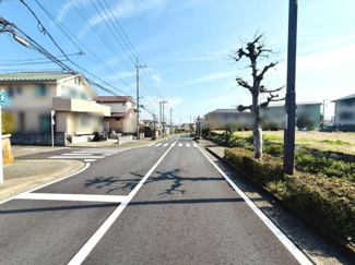 前面道路は幅員が広く見通しの良い直線道路が特徴です。両側に歩道も整備されており安心感があります。周辺には電柱や植栽がきれいに配置されています。住宅街の雰囲気も感じられ交通量も落ち着いた印象です。