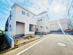 建物の並びや電柱など日常的な景色を見渡せます。前面道路がまっすぐ延びているのが印象的です。住宅や店舗が程よく配置された街並みが広がっています。空が広く感じられる見晴らしです。