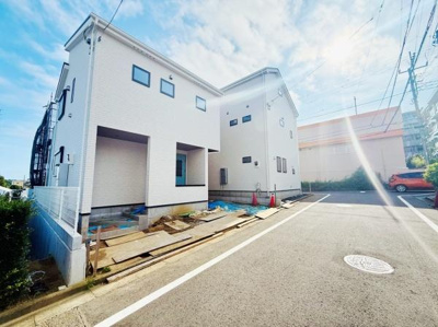 建物の並びや電柱など日常的な景色を見渡せます。前面道路がまっすぐ延びているのが印象的です。住宅や店舗が程よく配置された街並みが広がっています。空が広く感じられる見晴らしです。