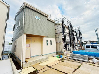 シンプルな外観が特徴的な新築戸建です。周囲には新しい住宅が建ち並び落ち着いた雰囲気となっています。玄関までのアプローチもすっきりとした印象です。