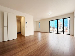 広々としたリビングは開放感が感じられるレイアウトです。大きな窓からはたっぷりと自然光が差し込みます。明るい室内と木目調の床が調和しています。