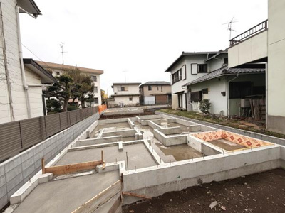 住宅街の一角に造成された基礎部分が確認できます。周囲には戸建て住宅が整然と並び落ち着いた住宅エリアが広がっています。敷地の形状や広さも分かりやすく新築計画のご検討に適した様子です。