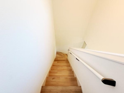 明るい色合いの壁と木目調の階段が調和しておりすっきりとした印象です。手すりも設置されていて安心感があります。シンプルなデザインが空間を広く感じさせます。メンテナンスもしやすい仕様となっています。