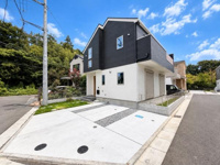 外観は白と黒のツートーンデザインで現代的な印象を与えます。角地に位置し開放感があります。駐車スペースも広く確保されています。静かな住宅街に建つ建物です。シンプルな外観が周囲と調和しています。
