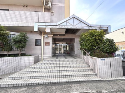 広々としたエントランスが開放的な印象を演出します。階段部分もゆとりを感じさせ植栽の緑が建物に彩りを添えています。ガラス扉による明るい雰囲気が魅力です。エントランスのデザインが全体の印象を引き立てます。
