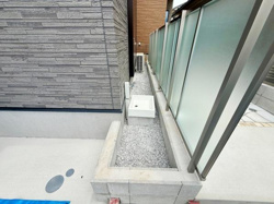 建物とフェンスの間に設けられたスペースに外水栓が設置され便利に使える設計です。グレーの外壁材やフェンスが調和し落ち着いた雰囲気を演出しています。