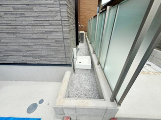 建物とフェンスの間に設けられたスペースに外水栓が設置され便利に使える設計です。グレーの外壁材やフェンスが調和し落ち着いた雰囲気を演出しています。