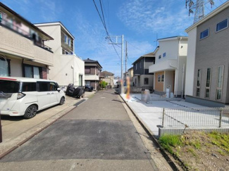 前面道路がしっかり舗装されており車の出し入れがしやすいです。周辺には新しい住宅が並び落ち着いた住環境が感じられます。電柱が整然と配置されており見通しの良い道沿いです。