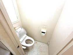 清潔感のあるトイレです。壁や床が明るい色合いなので全体的にすっきりとした印象です。コンパクトな空間ですが使いやすさが考えられています。換気のための窓も設置されています。