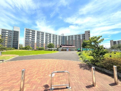 広々とした敷地に建つマンションが印象的です。空が大きく抜けて開放感があります。敷地内には緑も多く整えられた環境が感じられます。日当たりの良さが写真からもうかがえます。