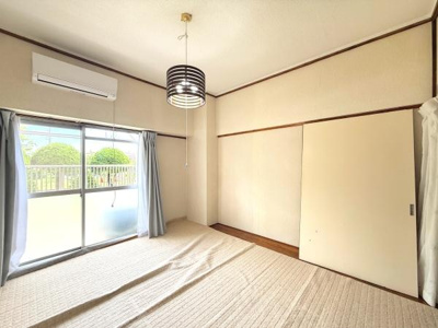 和室はやわらかな自然光が差し込み落ち着いた雰囲気が広がります。障子やカーテンがプライバシーを確保します。シンプルな造りが清潔感を感じさせます。エアコンも設置されているため一年を通して快適に過ごせます。