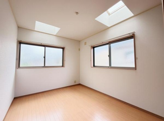 広々とした洋室はシンプルな内装で様々な用途に対応可能です。天窓と二面採光により室内には自然光がしっかりと差し込んでいます。落ち着いたフローリングが印象的です。明るく開放感のある空間です。