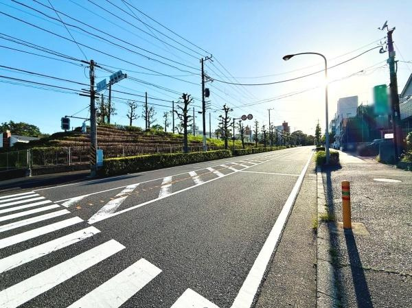 前面道路が広く歩道も整備されており見通しの良い環境です。電柱や標識が整然と配置され安心感があります。陽当たりも確保されておりすっきりとした印象の現地です。信号や横断歩道も近く交通利便性が感じられます。