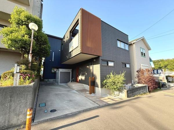 スタイリッシュな外観が目を引く住宅です。前面道路が広く車の出し入れもしやすい印象です。植栽がアクセントとなり整った街並みに調和しています。周囲には同様の住宅が並び静かな環境がうかがえます。