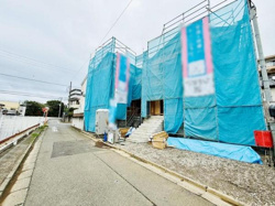 広々とした敷地は工事の進行状況が一目で分かる開放感があります。周辺には住宅や緑も見られ落ち着いた雰囲気です。資材や設備も整えられており建築の過程が目に見えます。明るい空が周囲を照らします。