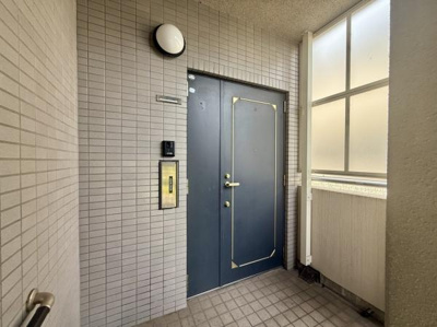 玄関ドアは落ち着いた色合いでシンプルなデザインが特徴です。明るい共用部分があり開放感があります。タイル張りの壁でお手入れもしやすい造りです。便利なインターホンも設置されています。