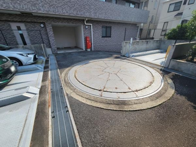 駐車場にはターンテーブル式の設備が整っています。車の出し入れがしやすい設計です。敷地内にはしっかりとした仕切りが設けられています。周囲もすっきりとした印象があります。敷地奥には車庫スペースもあります。