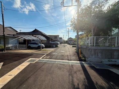 前面道路が広く車の出し入れもスムーズに行えます。周囲には住宅が並び静かな雰囲気が感じられます。日当たりも良好で明るい現地写真が印象的です。道路沿いはしっかりと整備されています。