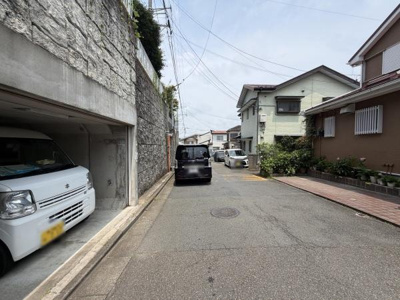 前面道路は落ち着いた雰囲気で車の出し入れもスムーズに行えそうです。周囲には住宅が整然と並んでおり道路幅にも余裕があります。現地の様子がしっかりと確認できる一枚です。