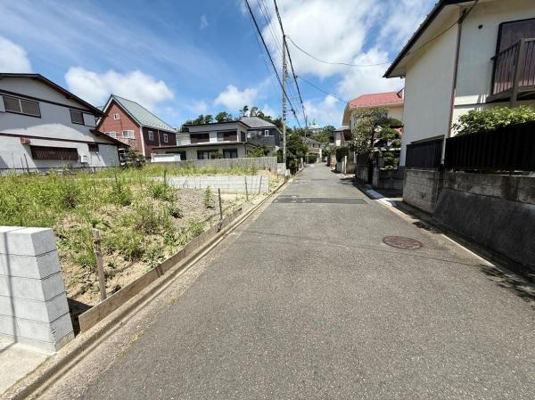 前面道路は舗装されており歩きやすい環境です。周囲には住宅が立ち並び整然とした街並みが広がっています。現地は日当たりも良くゆったりとした雰囲気を感じられます。周辺の住宅との調和がとれた場所です。