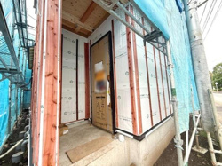 玄関アプローチ部分が広めに確保されています。建物の構造体がしっかりと施工されている様子が伺えます。外壁下地の丁寧な仕上がりが特徴です。建築現場の進行状況を確認できる貴重な一枚です。