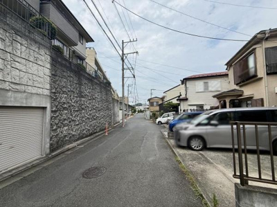 前面道路は幅があり車の出入りがしやすい環境です。周囲は閑静な住宅街で落ち着いた雰囲気が感じられます。道路沿いには整備された住宅が並んでおり整然とした街並みです。