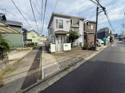 前面道路が広く車の出入りがしやすい現地写真です。周辺には同様の戸建住宅が並び落ち着いた住宅街の雰囲気が感じられます。電柱や配線が整然と配置され通行にも配慮された区画となっています。