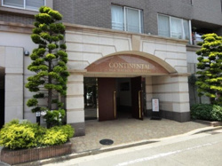 エントランスにはアーチ状のデザインが施されており外観に調和した植栽がアクセントとなっています。入口は広く開放感があります。建物の落ち着いた色合いが印象的です。