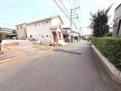 現地前面道路は幅員が広く車の通行もしやすい印象です。周囲の住宅も整然としており清潔感があります。歩道も整備されていて安心感があります。電柱や植栽など街並みが落ち着いた雰囲気です。