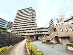 落ち着いた色合いの外観が特徴のマンションです。エントランスまでのアプローチが整備されており手すりも設置されています。複数の建物が連なるデザインが印象的です。周囲の建物との調和が感じられます。