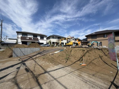 住宅街に位置する現地土地写真です。周囲には整然とした住宅が立ち並んでおり落ち着いた雰囲気が広がっています。整地作業が進められていて建築の計画が立てやすい土地状況です。