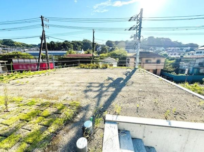 前面道路が広々としており開放感のある現地写真です。電柱や配管も整備されていて周囲の景観がすっきりしています。道路面が舗装されているため快適に利用いただけます。晴れの日の写真で明るい印象です。