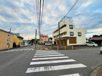 前面道路は幅が広く車両の出入りもしやすい配置です。周辺には建物が整然と立ち並び視界が開けています。交差点が近く交通の流れも分かりやすい環境です。