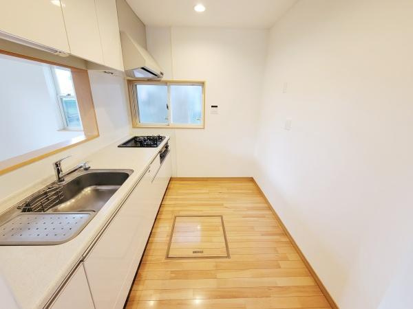 白を基調としたシンプルなキッチン。大きな窓から自然光が入り明るい空間です。床下収納も備えております。