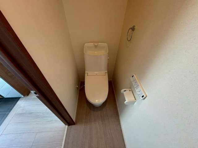手洗い一体型のスタイリッシュなトイレを採用。壁掛けリモコンやリング型のタオル掛けを完備し、すっきりとした印象です。玄関ホールに近く、帰宅直後や来客時にもスムーズに使える便利な配置です。