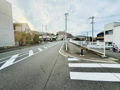 車道や歩道がしっかりと整備されている街並みです。周辺には住宅が立ち並び落ち着いた印象を受けます。道幅が広く開放感があります。周囲の建物も整然と配置されています。