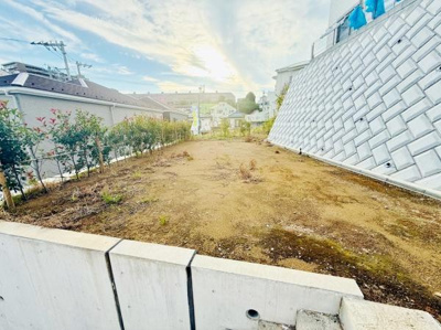 日当たりが良く開放的な雰囲気が広がっています。周囲には住宅が立ち並び落ち着いた環境です。敷地はすっきりとした形状で自由な利用が可能です。コンクリートの擁壁がしっかりとした印象を与えます。