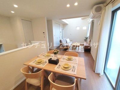 リビングには窓からの光が差し込み室内が明るく感じられます。ダイニングテーブルとソファが整然と配置され開放感が広がります。木目調の床とナチュラルなインテリアが調和し落ち着いた空間です。