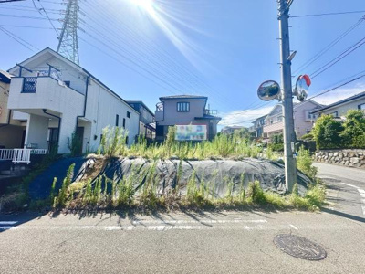 現地の前面道路は幅員が広く車の出入りがしやすい印象です。周囲には住宅が整然と立ち並んでいます。明るい日差しが差し込む開放的な街並みが特徴的です。電柱やカーブミラーなど安全面にも配慮が見られます。