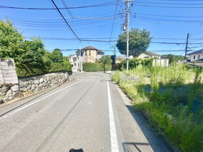 前面道路は広々としており車の出入りもスムーズに行えます。周囲には緑が多く落ち着いた雰囲気が広がっています。舗装もしっかりとされており安心してご利用いただけます。道路沿いには住宅が整然と並んでいます。