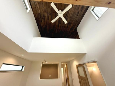 天井にシーリングファンを設置した開放感のある空間です。白を基調としたデザインに木目の天井がアクセントになっています。高い位置に窓があり室内に自然光が入ります。