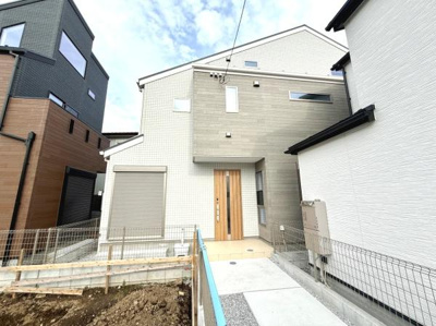 落ち着いた色合いの外観が現代的な雰囲気を演出しています。周囲には同じような新しい住宅が立ち並び地域全体が整っています。玄関までのアプローチも広く設計されており開放感があります。
