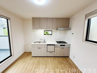 明るい光が差し込むキッチンはナチュラルな色合いで落ち着いた雰囲気です。コンパクトながら調理スペースも確保されています。窓が多く換気しやすい設計です。収納も充実しており日々の作業がしやすい空間です。