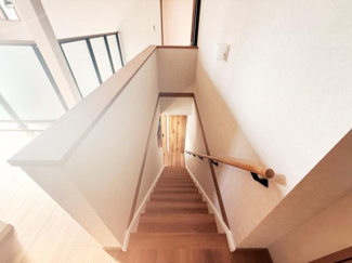 手すり付きの階段が設置されており上り下りも安心です。階段スペースは幅も確保され移動もしやすいです。室内の明るさを取り込む配置で開放感があります。廊下やリビングとつながる設計です。