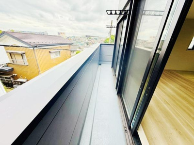 ワイドなバルコニーが設けられており開放感があります。透明なガラス窓が光を取り込み室内とのつながりも良好です。物干し金具も備わっているため家事にも役立ちます。遠くまで広がる景色が楽しめます。