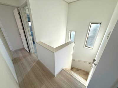 明るい光が差し込む階段スペースです。ナチュラルな床材が空間を引き立てています。各部屋への動線もスムーズで使い勝手の良いレイアウトです。階段の手すりも設置されています。